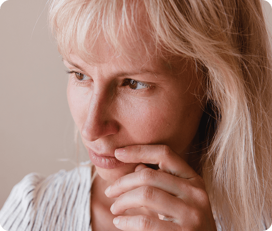 Vrouw kijkt peinzend voor zich uit