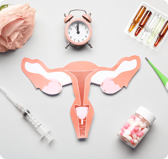 Papieren baarmoeder met een wekker, pillen en een injectiespuit