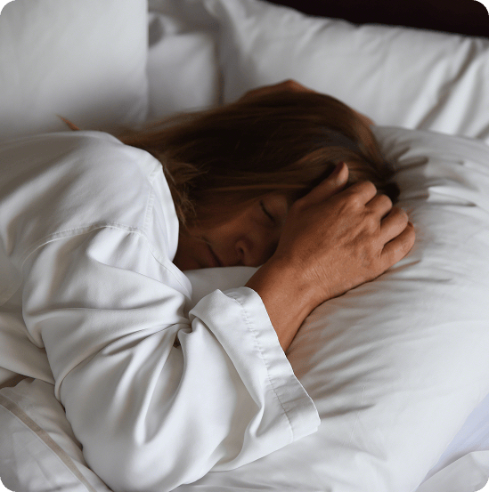 Vrouw ligt wakker in bed met haar hand aan haar hoofd