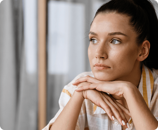 Vrouw kijkt nadenkend voor zich uit